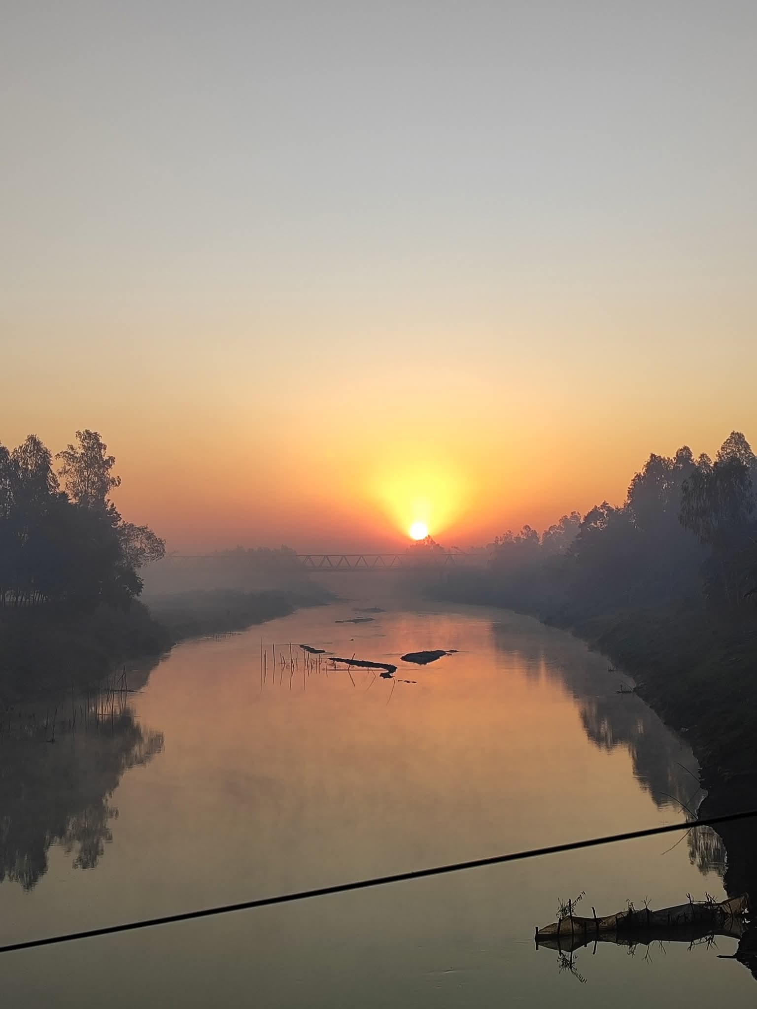 শান্ত জলের বুকে ভোরের আগুন রঙা অনুভূতি।