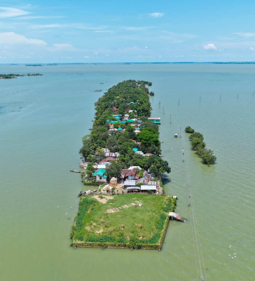 পানির মাঝে এক টুকরো গ্রামের সুন্দর দৃশ্য।